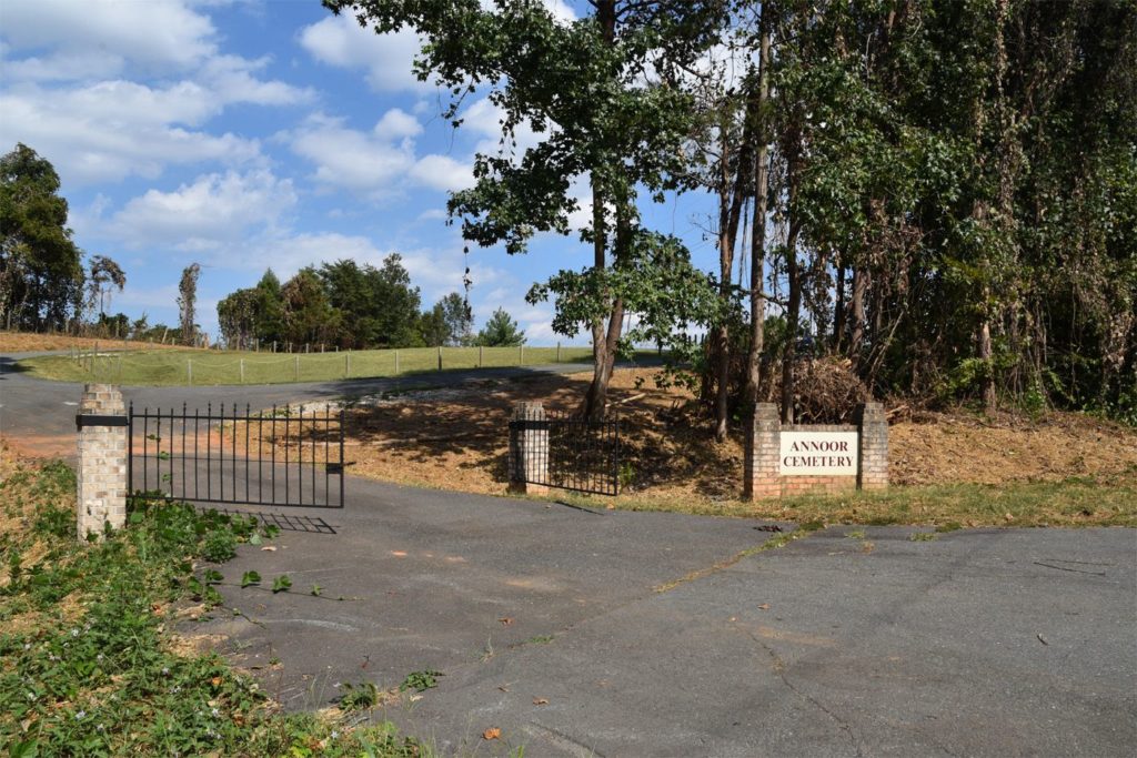 Gated entrance to Clemmons Islamic Center Cemetery, with trees and an access road.