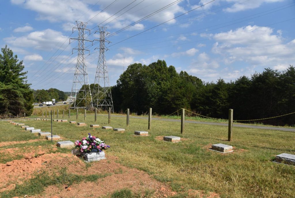 Burial grounds at Clemmons Islamic Center Cemetery, with rows of grave markers and surrounding trees.
